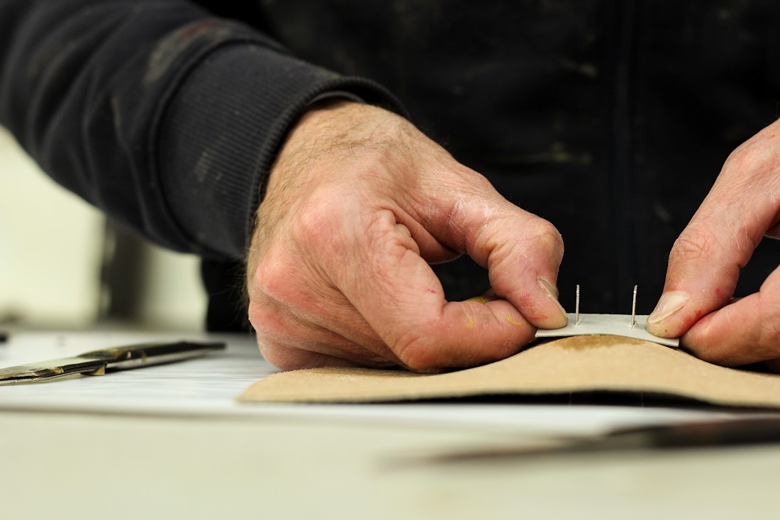 The hands of a Del Giudice Roma craftsman make a bag